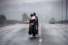 Un réfugié syrien embrasse sa fille pendant qu’il marche à travers la plus torrentielle en direction de la frontière gréco-macédonienne, à proximité du village d’Idomeni - 10 septembre 2015 - REUTERS/Yannis Behrakis