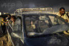AFP 18 / IRAK 22 octobre 2016 - Qayyarah, Irak - Un père et ses deux enfants arrivent dans un centre pour réfugiés alors que plus de 10 000 Irakiens ont déjà fui leur foyer depuis le début de l’offensive terrestre qui a commencé le 17 octobre. L’épaisse fumée noire qui s’élève à l’horizon provient des champs de pétrole qui ont été incendiés par le groupe État Islamique. AFP / BULENT KILIC